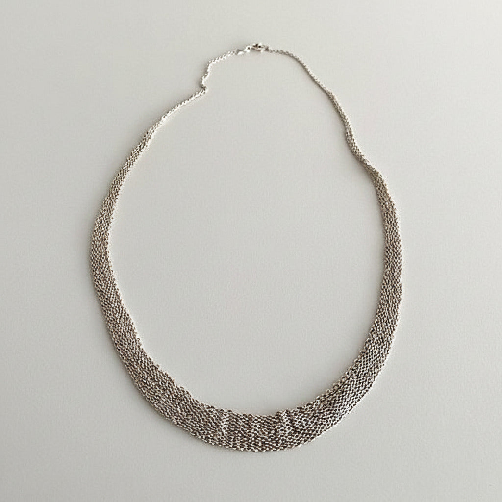 Tour de cou dégradé composé de plusieurs chaînes en argent assemblées  ensemble au fil de soie. Fermoir anneau ressort. Un collier délicat fait entièrement à la main par l'artiste belge Ria Lins.