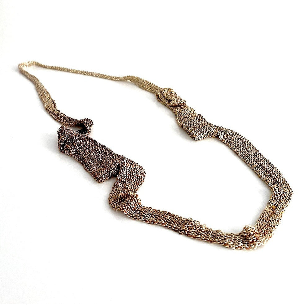 Long collier mordoré, en forme de ruban dégradé composé de chaîne d'argent patiné et fil de soie, assemblée. Une pièce délicate réalisée entièrement à la main par l'artiste Ria Lins.