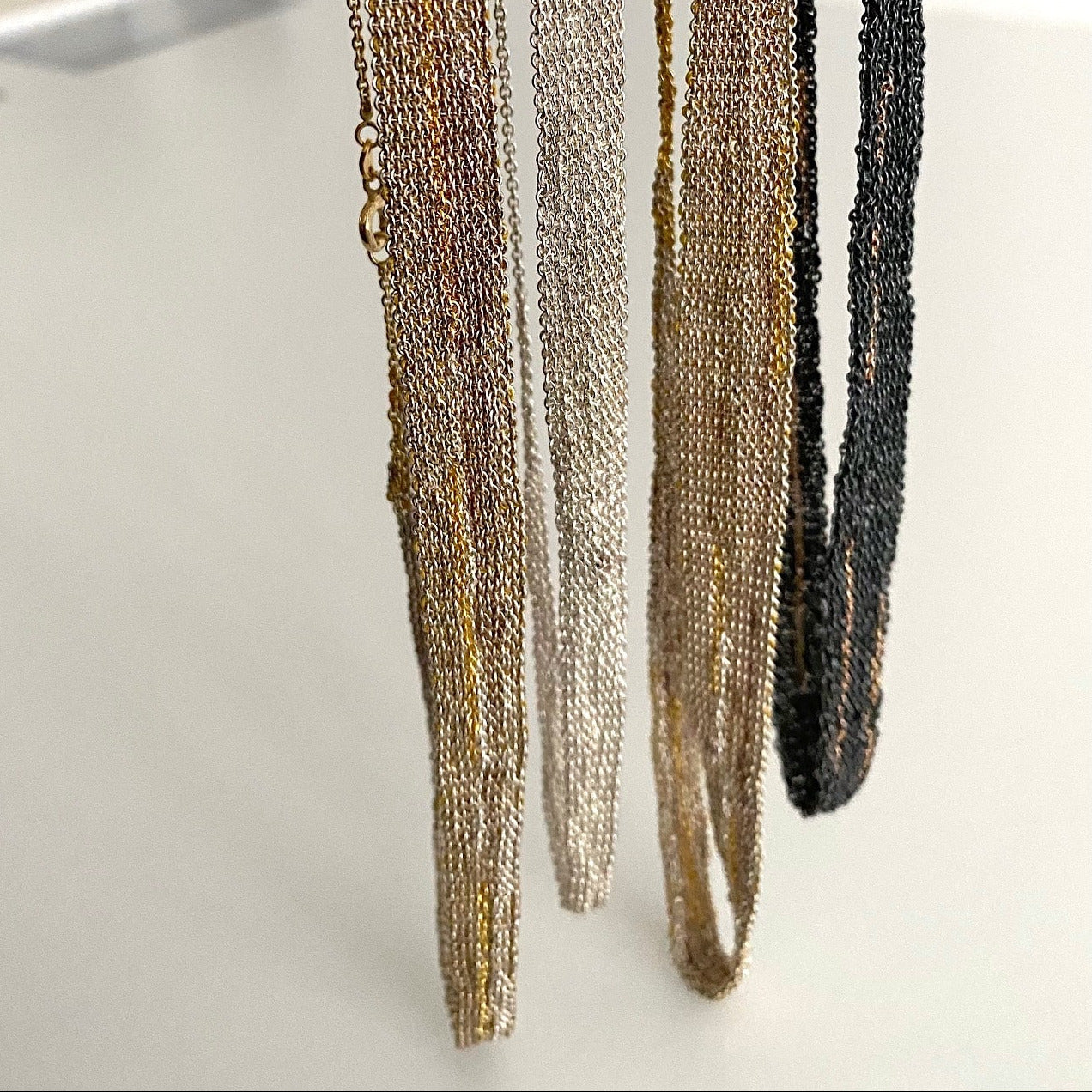 Détails de colliers contemporains de l'artiste belge Ria Lins. Un travail artisanal fait main.