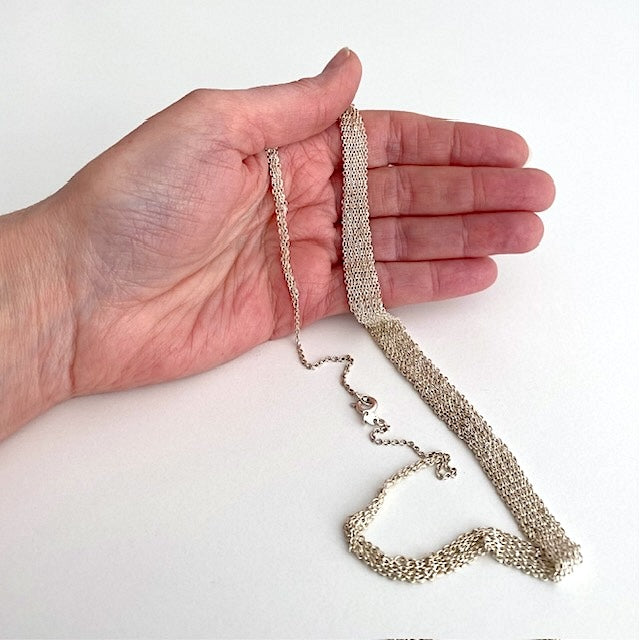 Collier dégradé composé de plusieurs chaînes en argent assemblées  ensemble au fil de soie. Fermoir anneau ressort. Un collier délicat fait entièrement à la main par l'artiste belge Ria Lins.