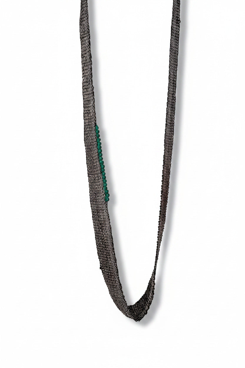 Long collier composé de chaines en argent oxydé noir assemblées au fil de soie, orné de 20 perles d’agate verte., sur un côté du bijou. Pièce unique artisanale.