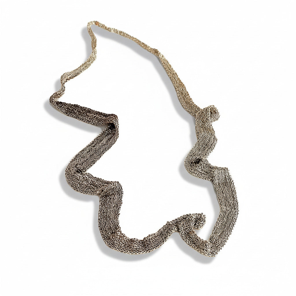 Long collier dégradé en forme de ruban composé de chaîne d'argent patiné mordoré assemblées entre elles au fil de soie. 