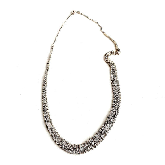 Tour de cou dégradé composé de plusieurs chaînes en argent assemblées les ensemble au fil de soie. Fermoir anneau ressort. 