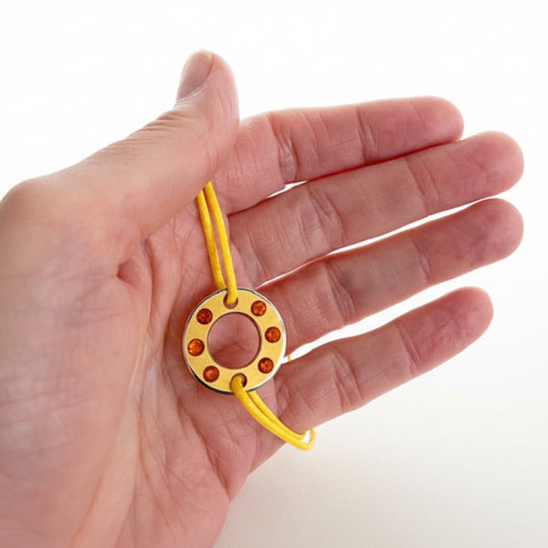 Bracelet Ready-Made, rondelle en  aluminium jaune serti de six opales de feu. bijou contemporain et unisexe présenté sur lien de coton réglable jaune. 