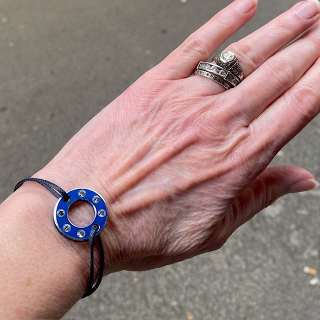 Bracelet Ready-Made, rondelle en  aluminium bleu et six saphirs blancs. bijou upcyclé inspiration moto, présenté sur lien de coton réglable. Un bracelet au design contemporain à porter au quotidien.