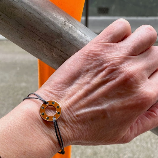 Bracelet Ready-Made, petit modèle est façonné d'une rondelle en aluminium orange et six tourmalines vertes. bijou upcyclé, présenté sur lien de coton réglable. Un bracelet au design contemporain à porter au quotidien.