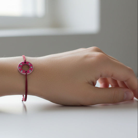 Collection Ready-Made, bracelet upcyclé fait main en rondelle d'aluminium anodisé rouge serti de six aigue-marines. Bijou contemporain et unisexe présenté ici sur un poignet de femme.