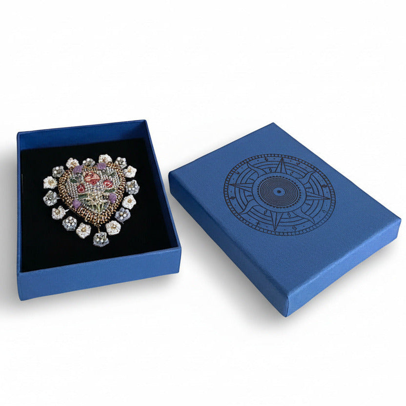 Broche Heritage Heart brodée main au détails fleuries. Bijou présenté dans sa boite bleu, prêt à offrir.