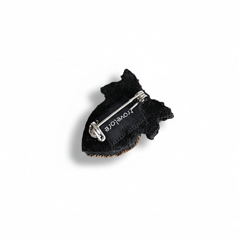 La petite broche Cœur de houx évoque un cœur d’or couronné de feuillage et d'une fleur.