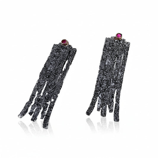 Boucles d'oreilles contemporaines longues de forme rectangulaires en argent patiné, texturé ornées d'un rubis à la base de l'oreille. Un design moderne inspiré de la tradition hellenique séculaire, une pièce organique façonnée à la main par Apostolos Kleitsiotis, artisan joaillier grec.