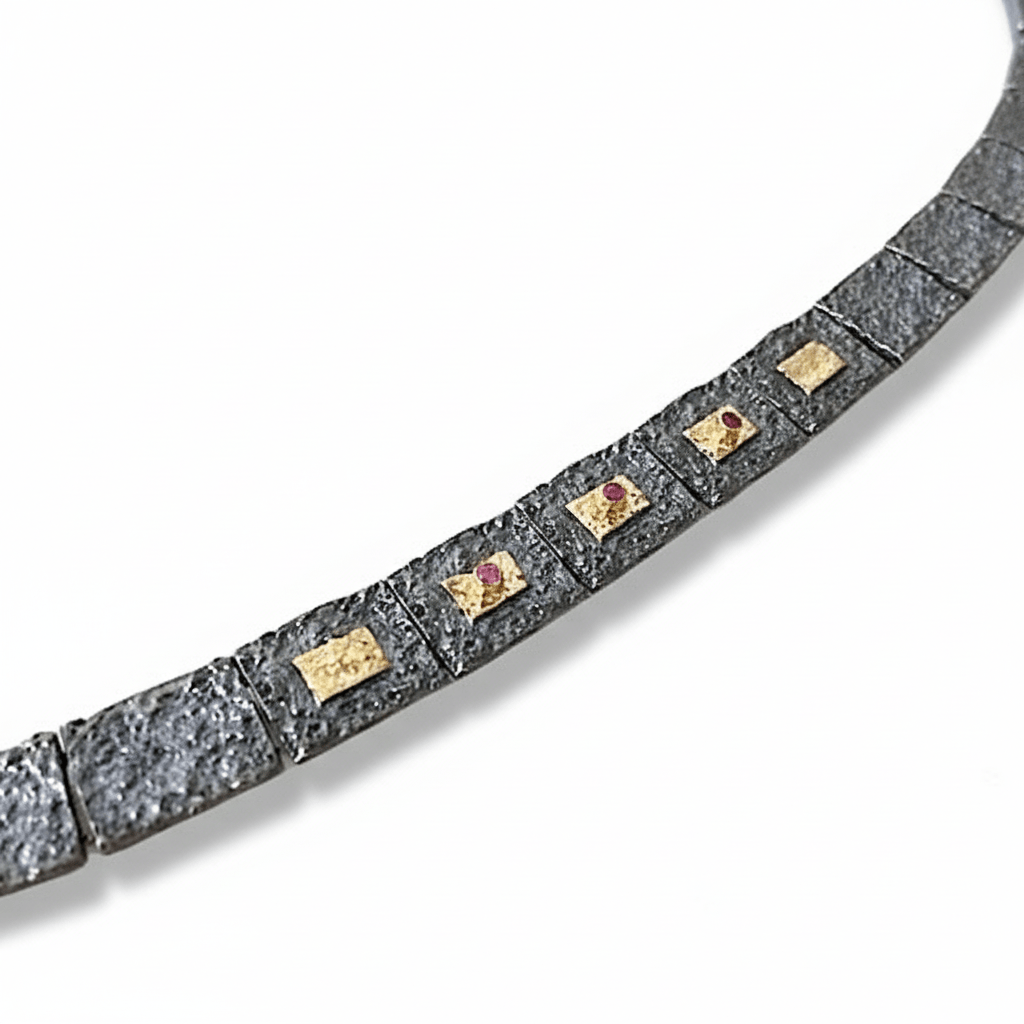 Bracelet contemporain articulé en argent patiné noir, composé de 13 éléments rectangulaires, ornés de 5 rectangles or jaune et 3 rubis sertis. Un bijou fait main par l'artisan joaillier Grec Apostolos Kleitsiotis.