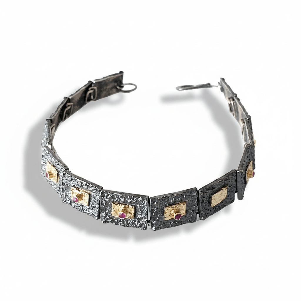 Bracelet articulé argent patiné, composé de 13 éléments rectangulaires, ornés de 5 rectangles or jaune et 3 rubis sertis. 