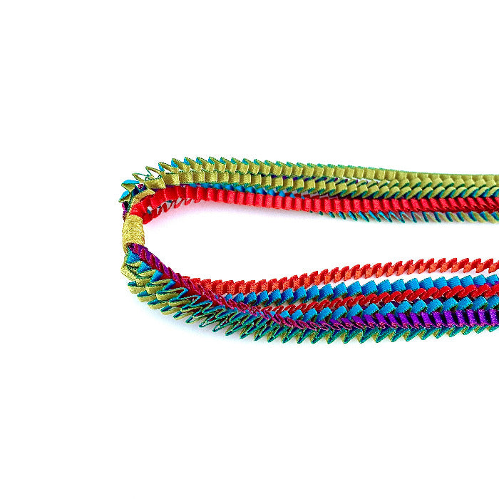Long sautoir coloré composé de huit bandes de satin plissé turquoise, doré,r ouge,orange, violet, fuchsia reliées les unes aux autres par un lien de coton jaune.