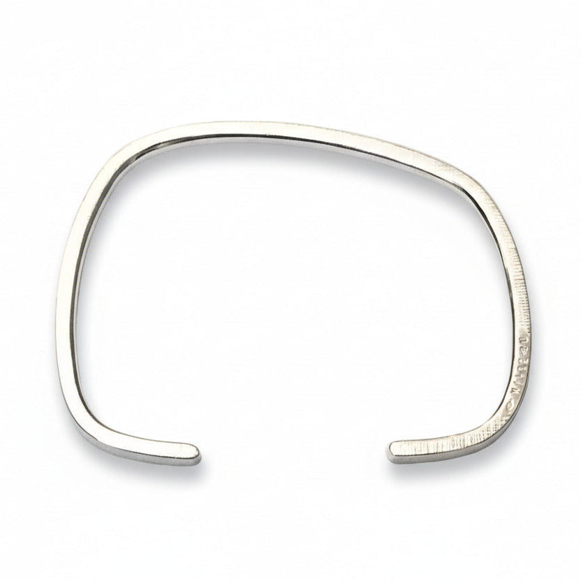 Bracelet géométrique en argent forgé au fil carré, jonc ouvert au design asymétrique. Modèle mixte, surfaces striées et intérieur poli. Bijou design contemporain, bijou minimaliste, une création artisanale signée Anne Milbeau.