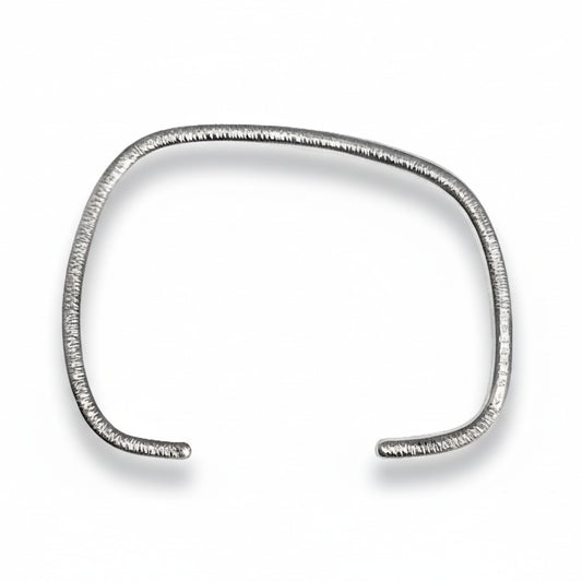 Bracelet géométrique en argent forgé au fil rond, jonc ouvert au design asymétrique. Modèle mixte, surfaces striées  et intérieur poli. Bijou design contemporain, bijou minimaliste, une création artisanale signée Anne Milbeau.
